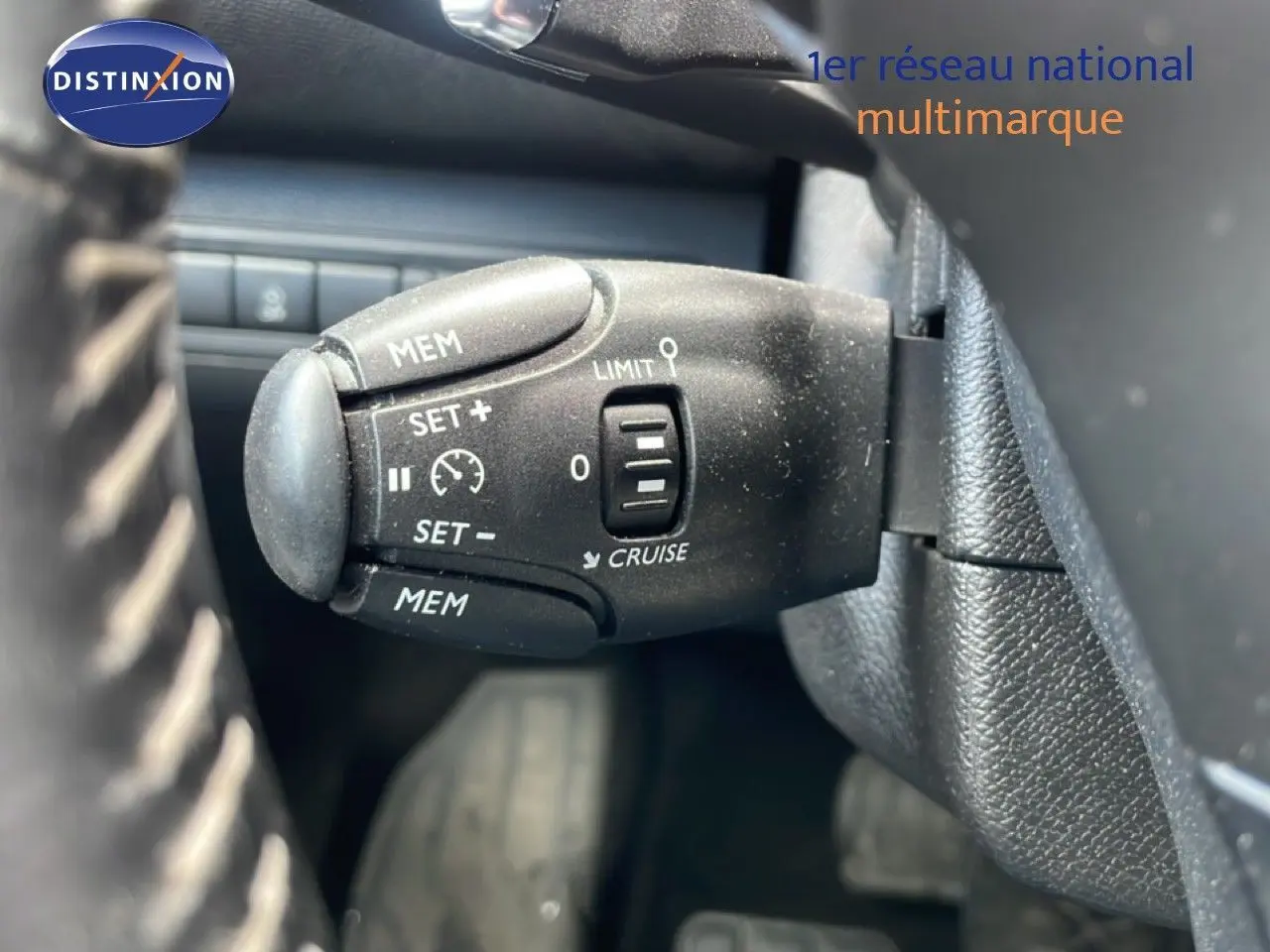 Gros plan sur la commande de régulateur de vitesse au volant d’un Peugeot 308 SW noir Perla Nera 2019.