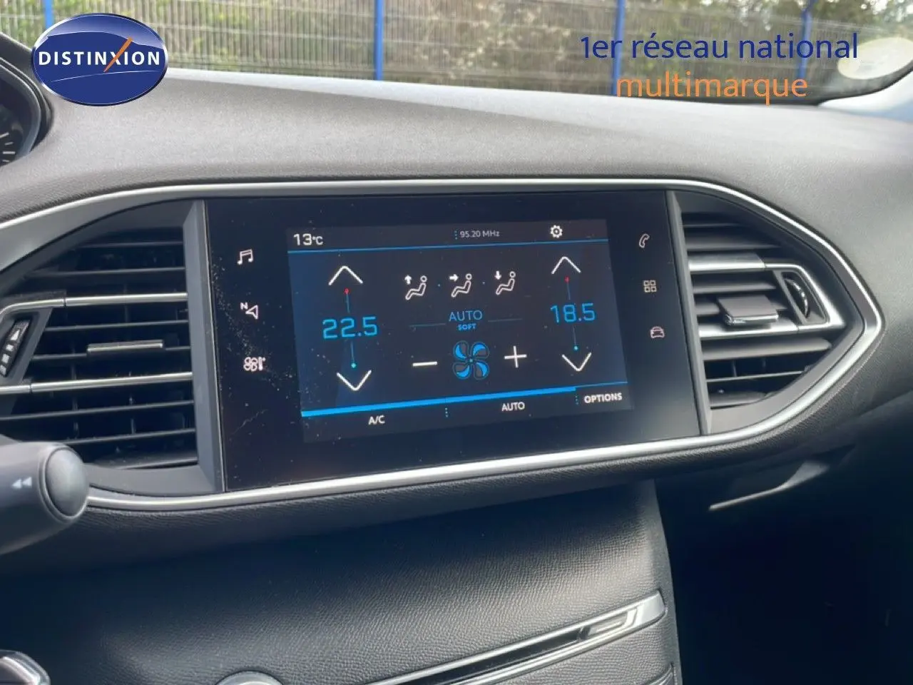 Vue rapprochée de l’écran tactile central du tableau de bord de la Peugeot 308 SW noir Perla Nera, affichant la climatisation automatique.