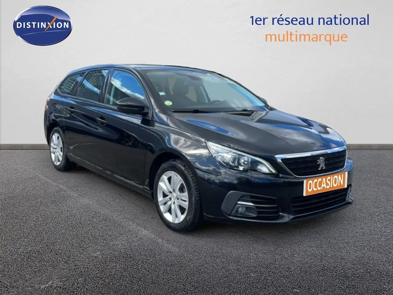 Peugeot 308 SW noire vue en 3/4 avant droit, avec calandre chromée et jantes alliage argentées.