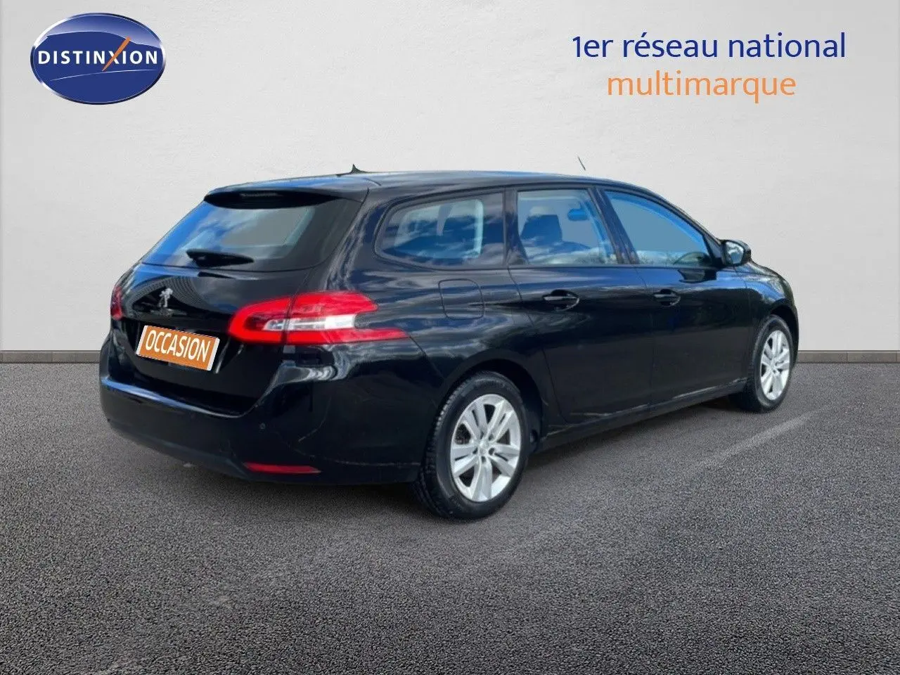 Peugeot 308 SW noire vue 3/4 arrière côté droit, avec feux arrière allongés et jantes argentées.