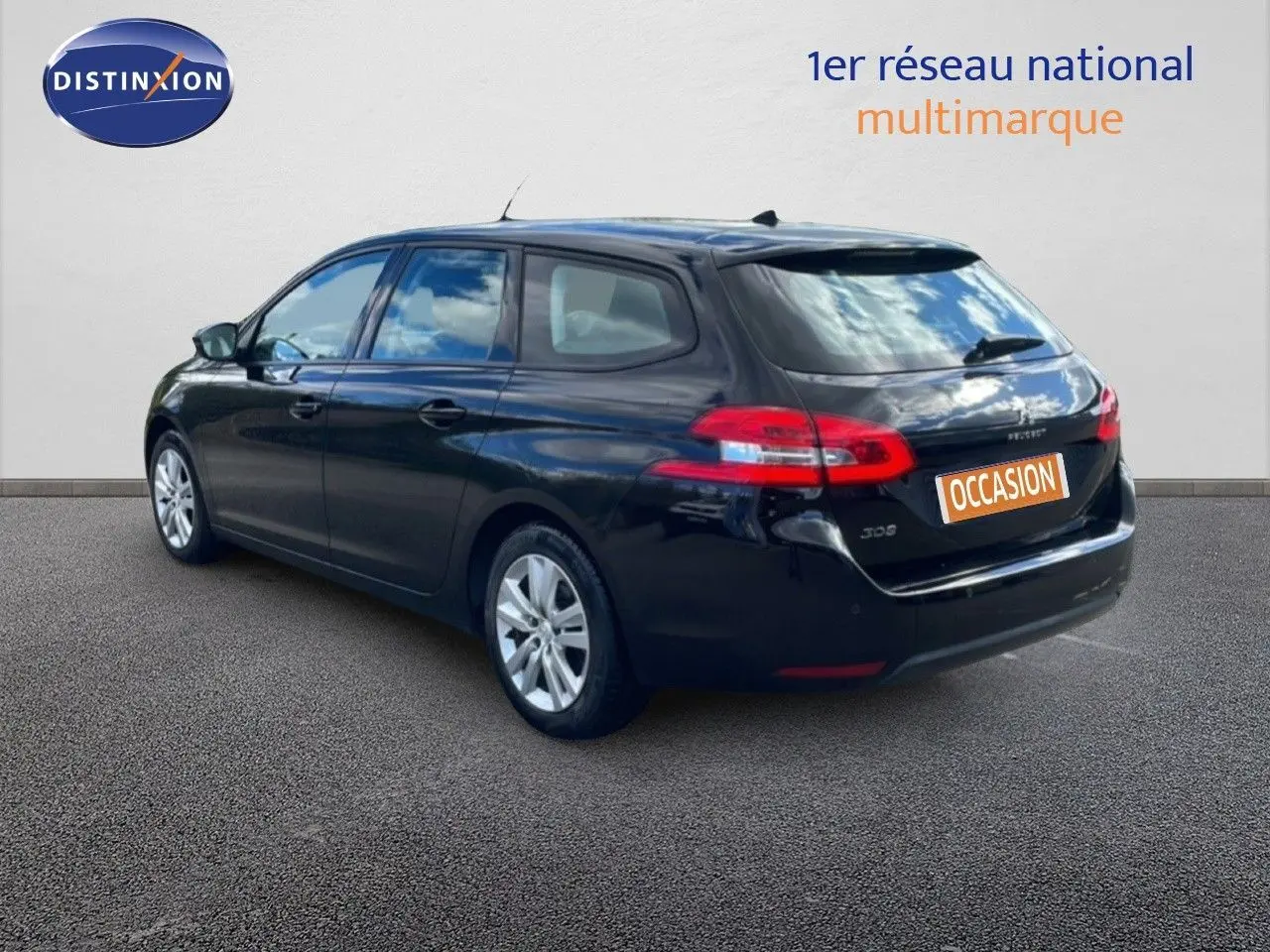 Peugeot 308 SW noir perla nera, vue 3/4 arrière droit, avec feux arrière allongés et jantes argentées.