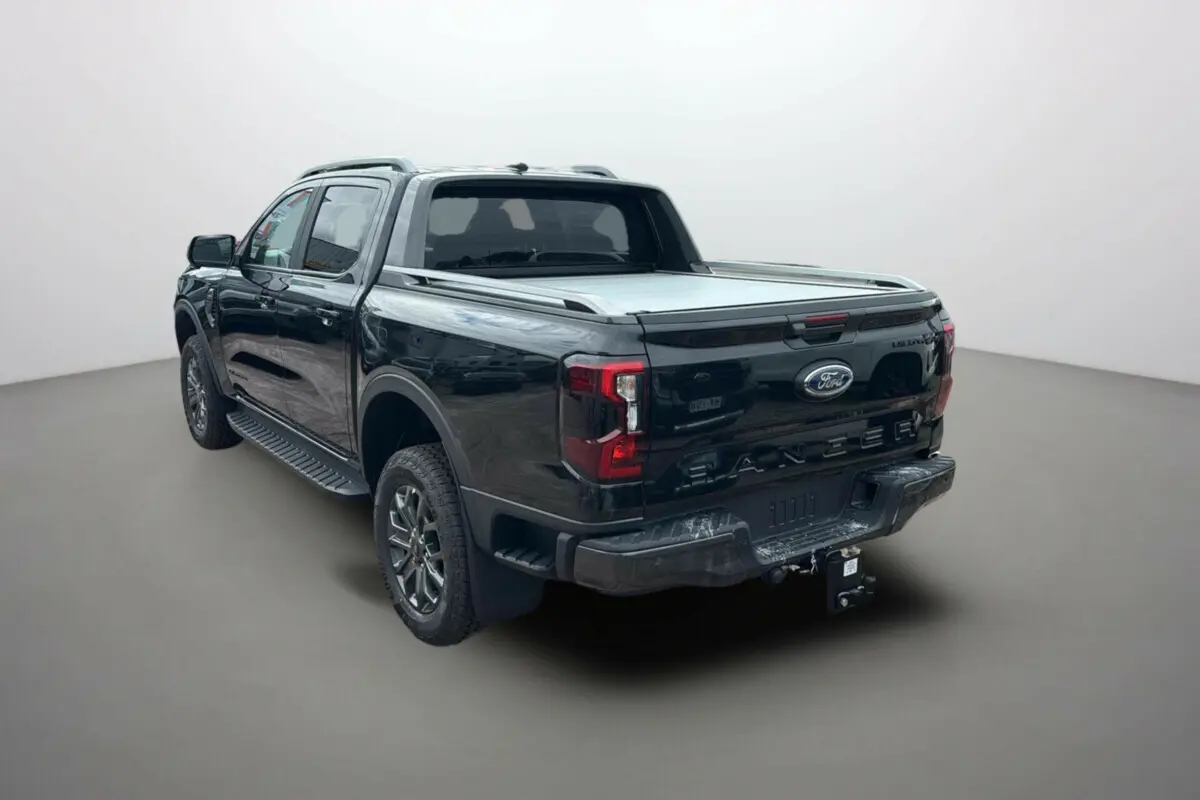 Vue 3/4 arrière droite du Ford Ranger noir agate avec benne couverte et attelage visible.