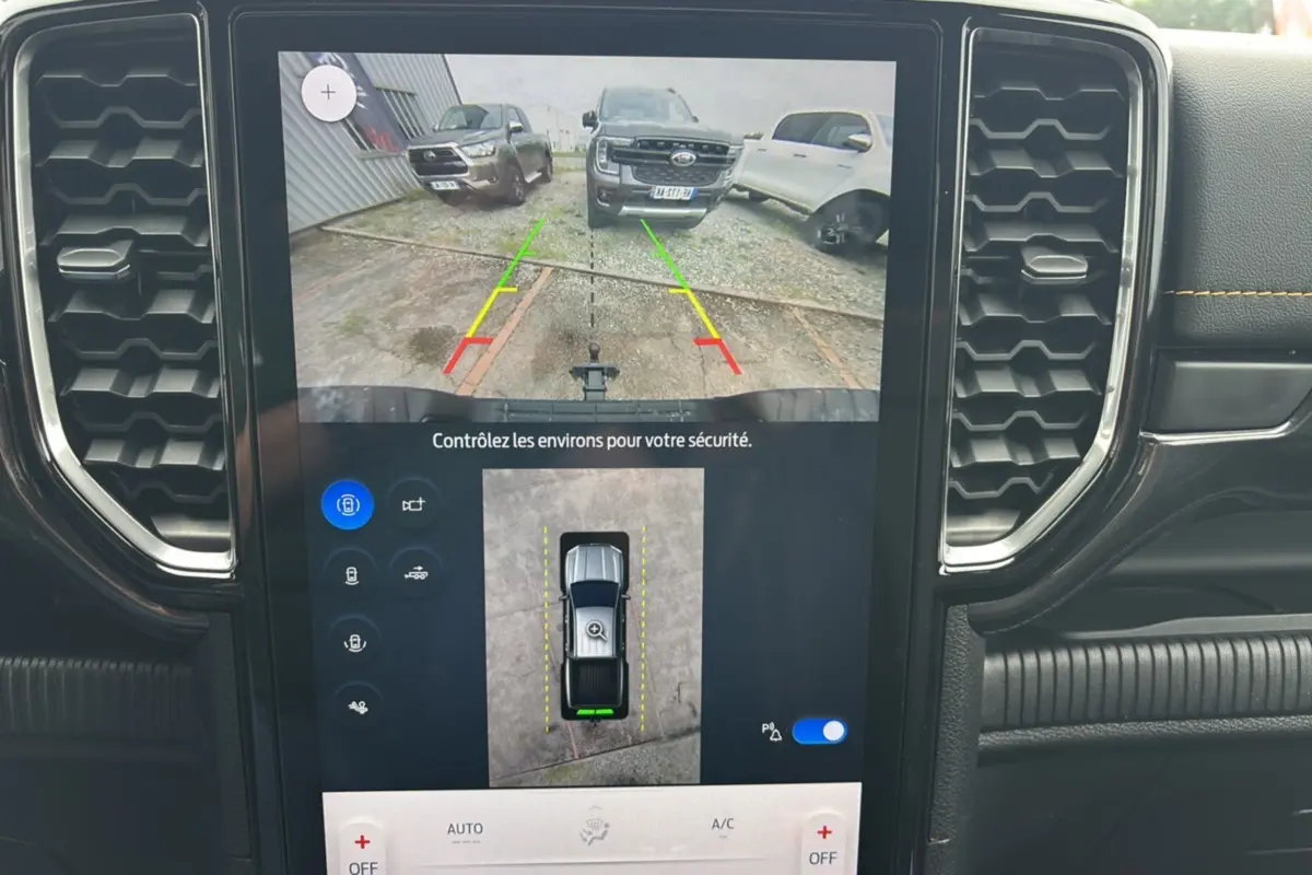 Écran central montrant la caméra de recul du Ford Ranger noir agate, avec vue arrière et lignes de guidage colorées.
