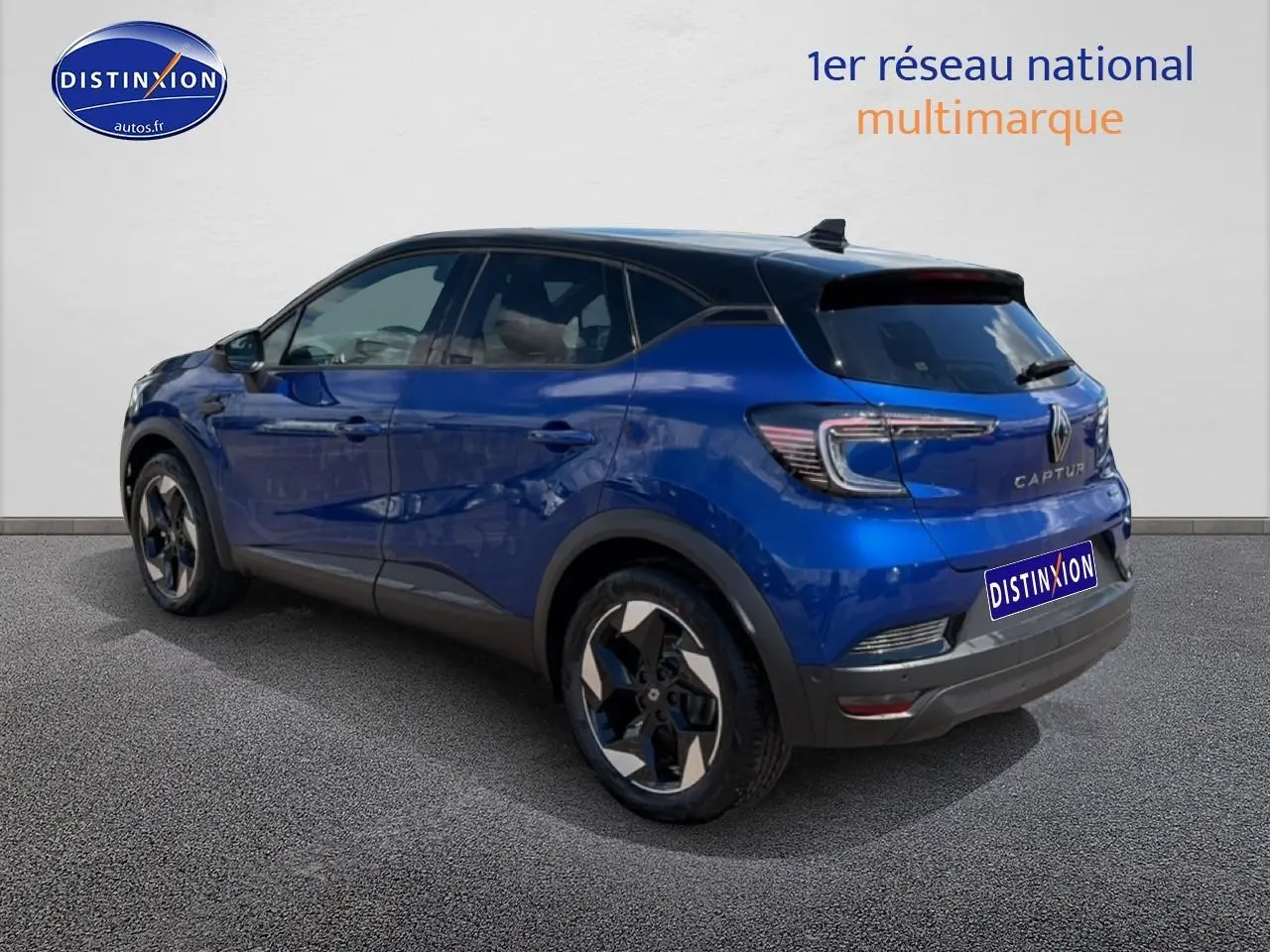 Vue 3/4 arrière droite d'un Renault Captur 2026 bleu iron avec toit noir et jantes alu noires.