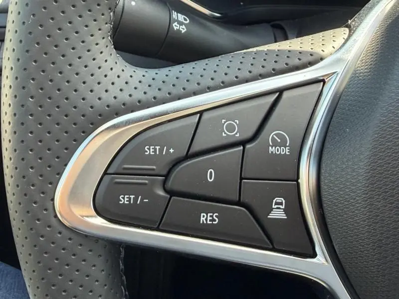 Gros plan sur les commandes multifonctions à gauche du volant perforé du Renault Captur blanc nacré 2026.