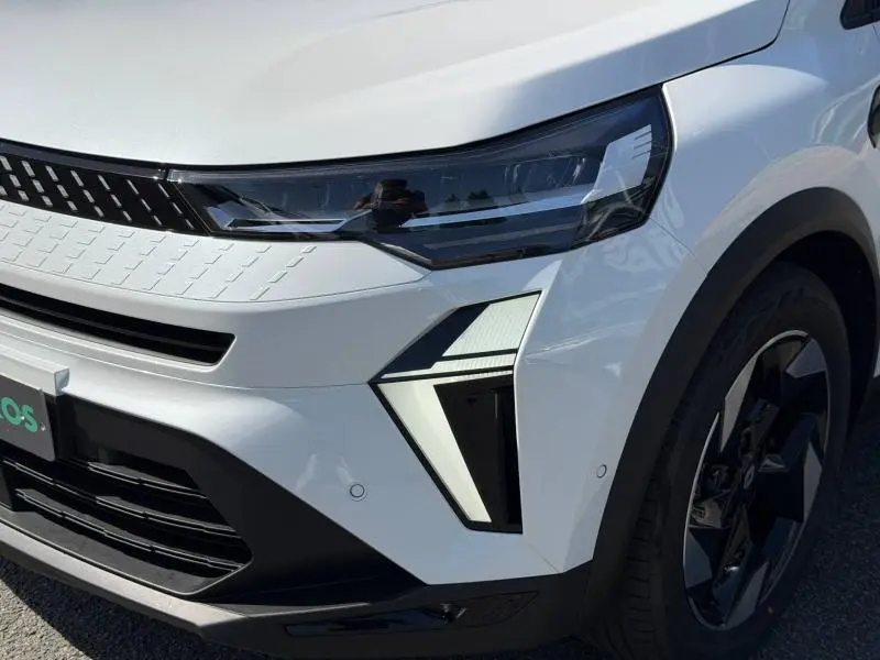 Gros plan sur l’avant droit du Renault Captur blanc nacré 2026, mettant en valeur les phares LED et la jante noire.