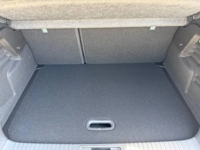 Coffre ouvert du Renault Captur blanc nacré 2026, vue intérieure montrant le plancher de coffre plat et propre.