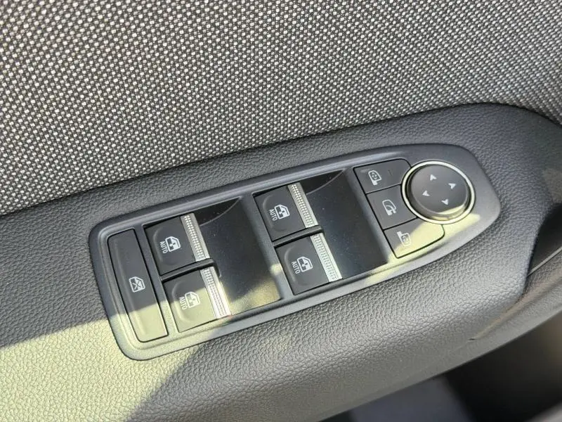 Gros plan sur les commandes des vitres électriques et rétroviseurs sur la porte avant côté gauche du Renault Captur blanc nacré.