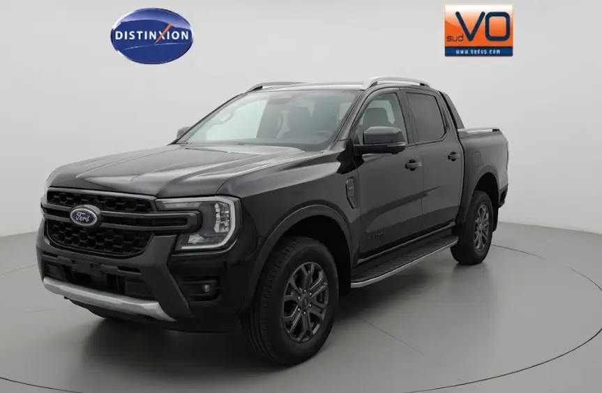 Ford Ranger Wildtrak noir en 3/4 avant droit, avec barres de toit, marchepieds et jantes alliage 18 pouces.