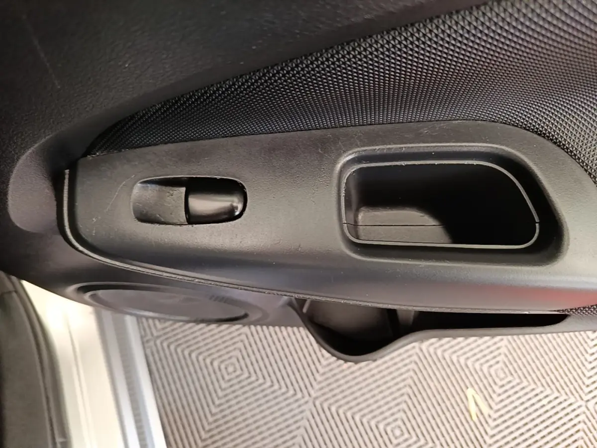 Détail de la poignée intérieure de porte côté conducteur du Nissan Juke gris clair 2023, finition Business Edition.