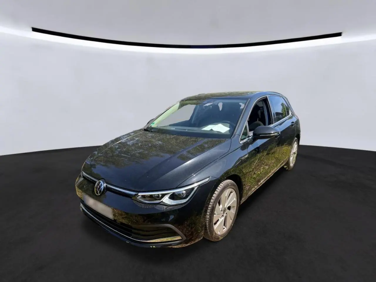 Volkswagen Golf VIII noire vue en 3/4 avant droit, avec jantes alliage et phares LED distinctifs.