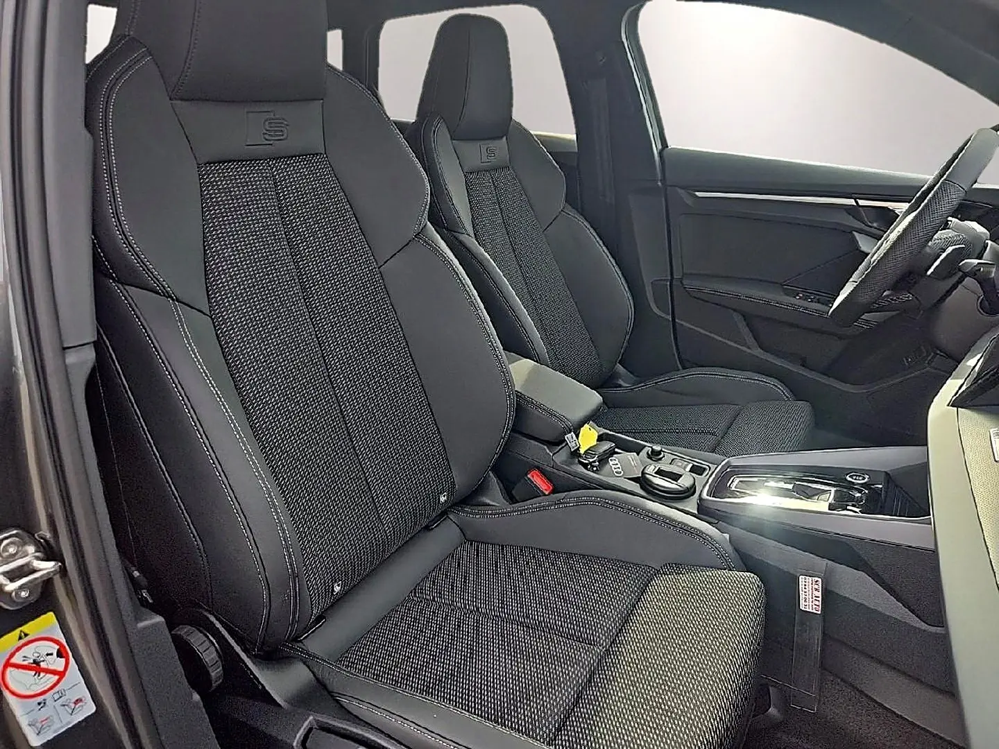 Vue intérieure côté conducteur de l’Audi A3 Sportback 1.5 TFSI S line 2026 avec sièges sport noirs et console centrale moderne.