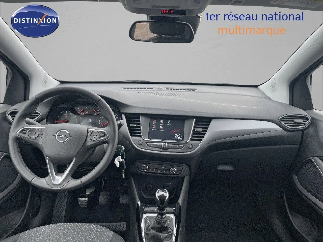 Vue intérieure avant de l'Opel Crossland 2022, tableau de bord noir avec écran tactile et levier de vitesse manuel.