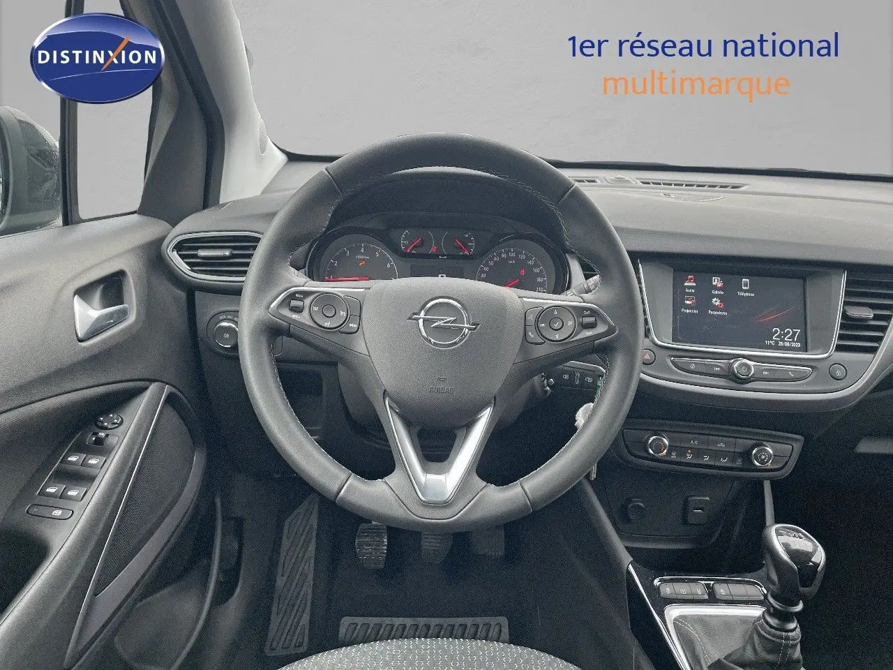 Vue intérieure centrée sur le volant et tableau de bord de l'Opel Crossland gris minéral, avec écran tactile et boîte manuelle.