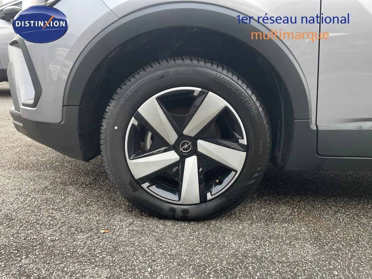 Gros plan sur la roue avant gauche de l'Opel Crossland gris minéral métal avec jante alliage bicolore moderne.