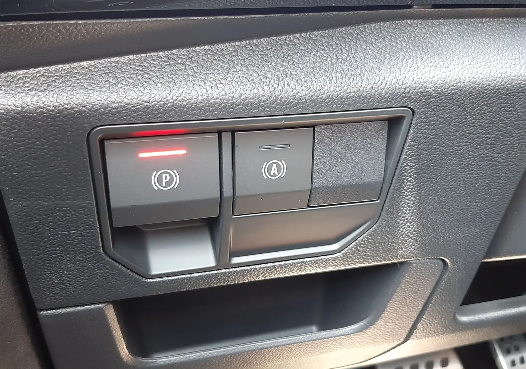 Gros plan sur les commandes de frein à main électronique et arrêt automatique du moteur du Renault Espace VI gris schiste.