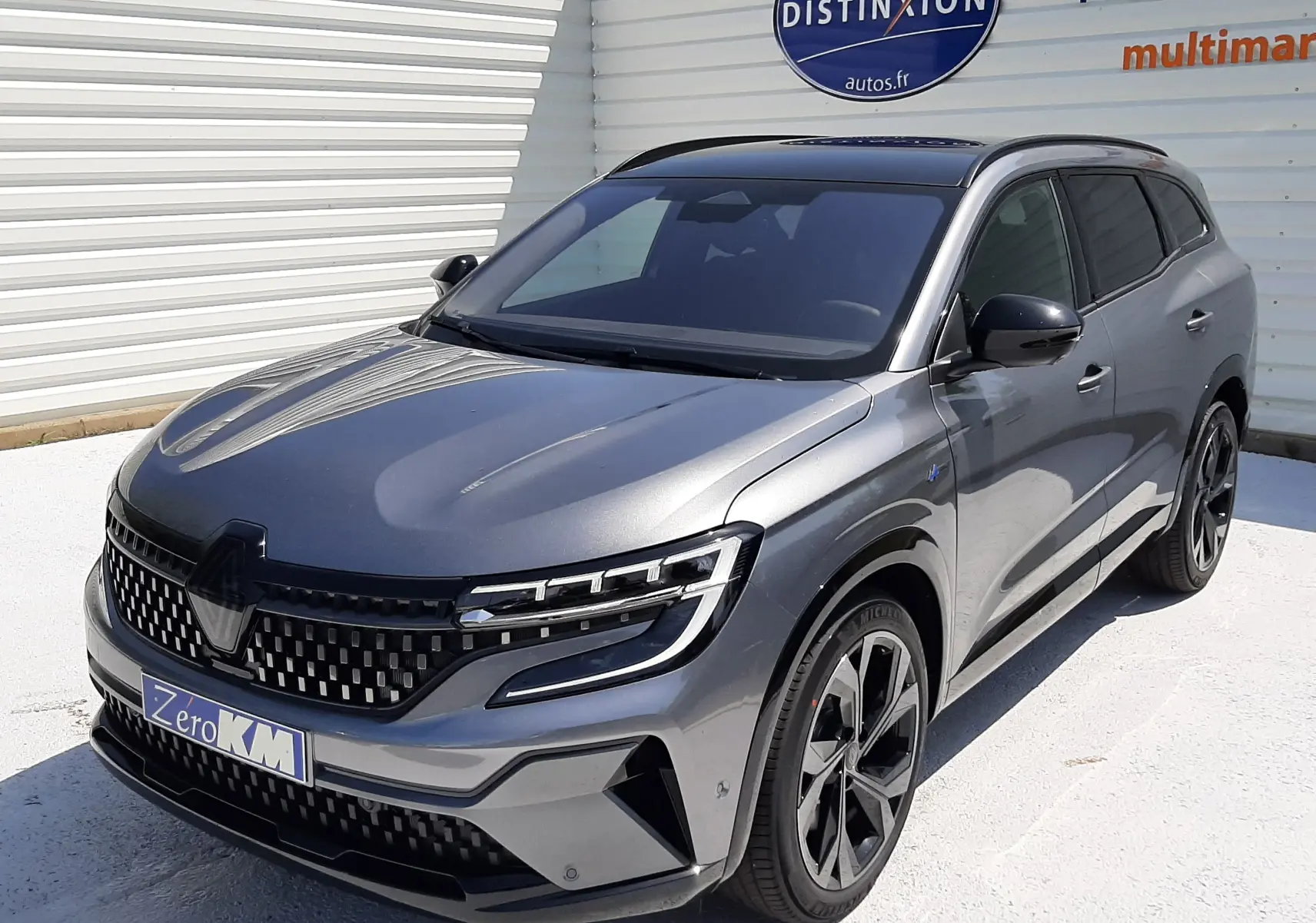 Renault Espace VI gris schiste métal en 3/4 avant droit, avec calandre moderne et jantes noires distinctives.