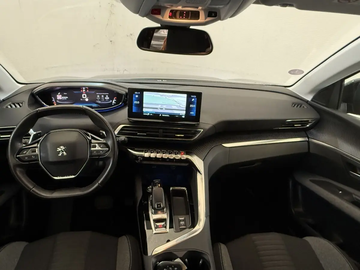 Vue intérieure avant du Peugeot 3008 bleu 2021, tableau de bord moderne avec écran tactile et volant cuir multifonctions.