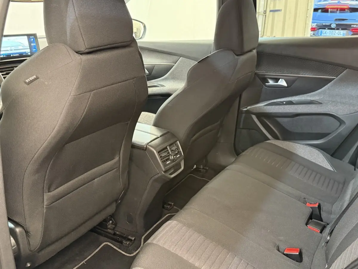 Vue intérieure arrière du Peugeot 3008 bleu 2021, sièges tissu noirs avec aérateurs centraux et portes côté droit.