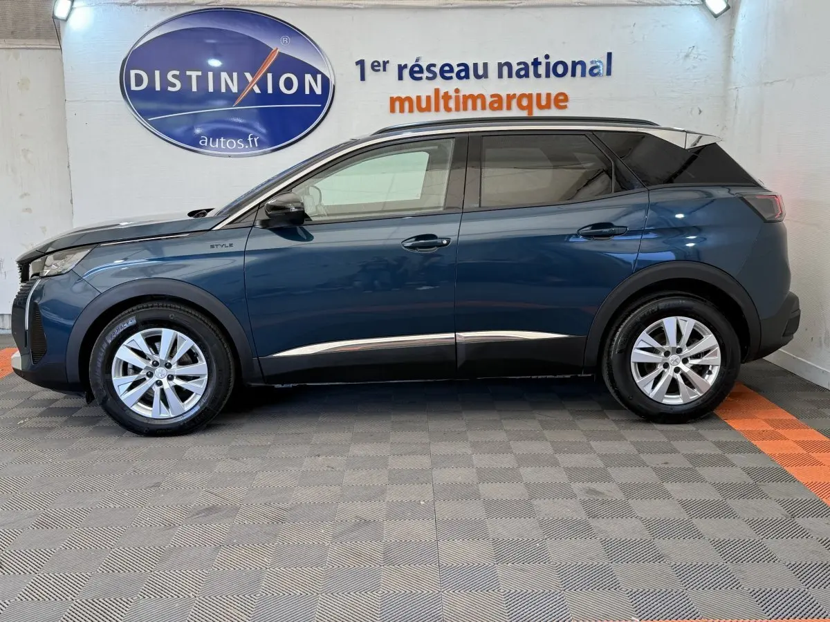 Vue de profil côté gauche d’un Peugeot 3008 bleu 2021 version Style avec toit noir et jantes argentées.