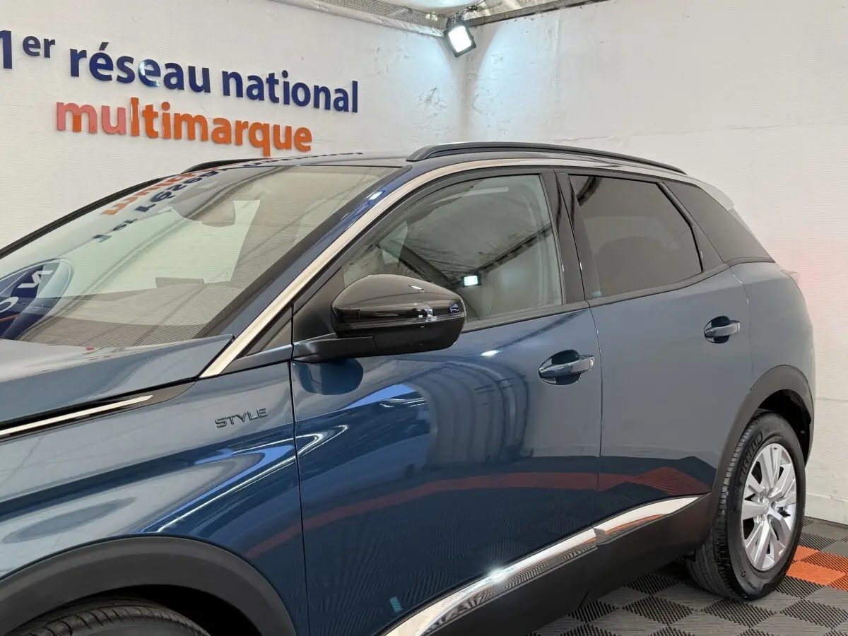 Vue côté gauche du Peugeot 3008 bleu Style 2021 avec rétroviseurs noirs et baguettes chromées sur les portes.
