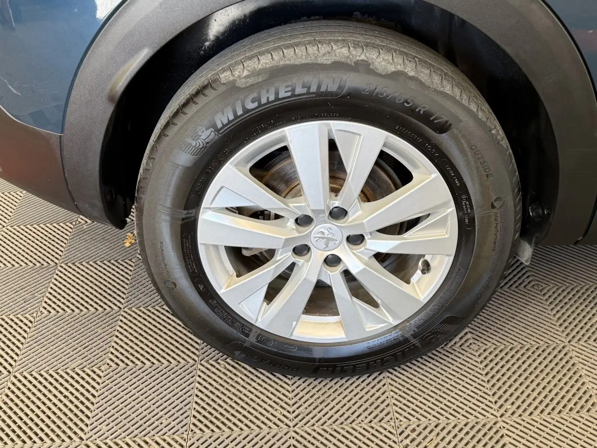 Gros plan sur la roue avant droite du Peugeot 3008 bleu, avec jante alliage argent et pneu Michelin.