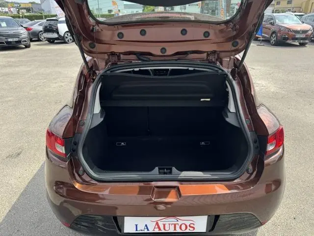Vue arrière ouverte sur le coffre d'une Renault Clio IV marron, montrant l'espace de chargement vide et la plage arrière.