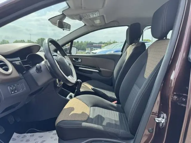 Intérieur côté conducteur d'une Renault Clio IV marron, montrant les sièges tissu bicolore et le volant multifonction.