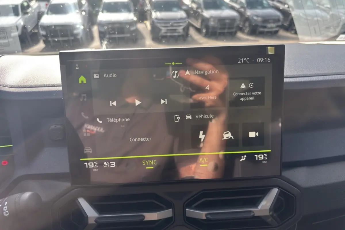 Écran tactile central du tableau de bord du Dacia Bigster Hybrid-G 150, affichant navigation et climatisation.