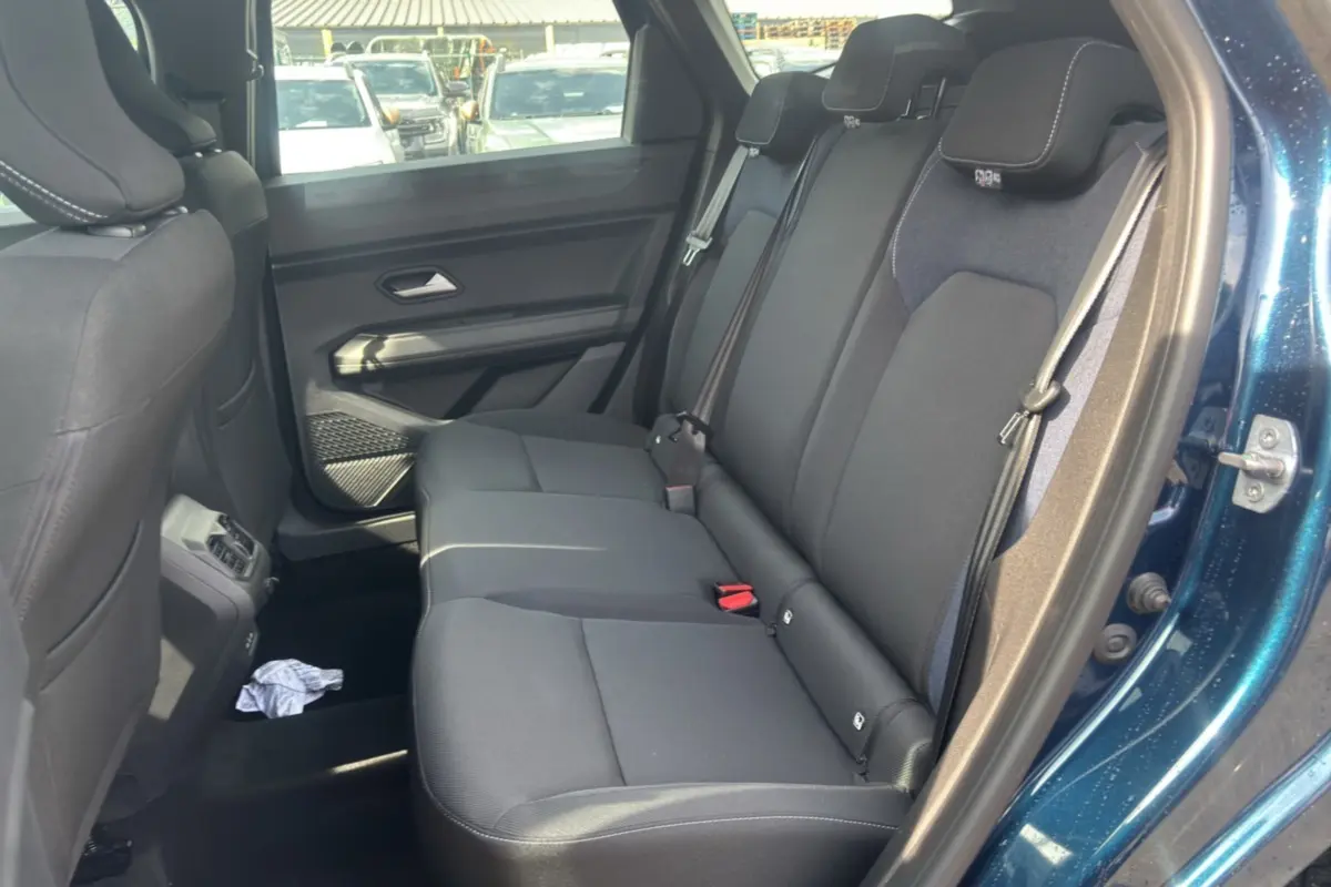 Vue intérieure côté droit sur la banquette arrière noire du Dacia Bigster bleu indigo avec porte ouverte.