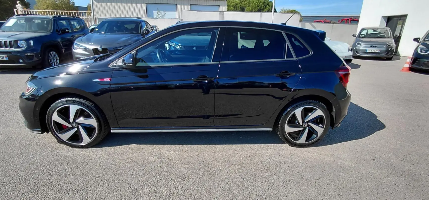 Volkswagen Polo 2.0 TSI GTI noire vue de profil côté gauche, avec jantes alliage 17 pouces et badge GTI rouge.