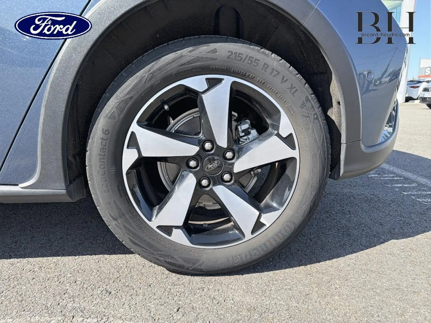 Gros plan sur la roue avant droite de la Ford Focus bleu azur métallisé avec jante alliage bicolore.