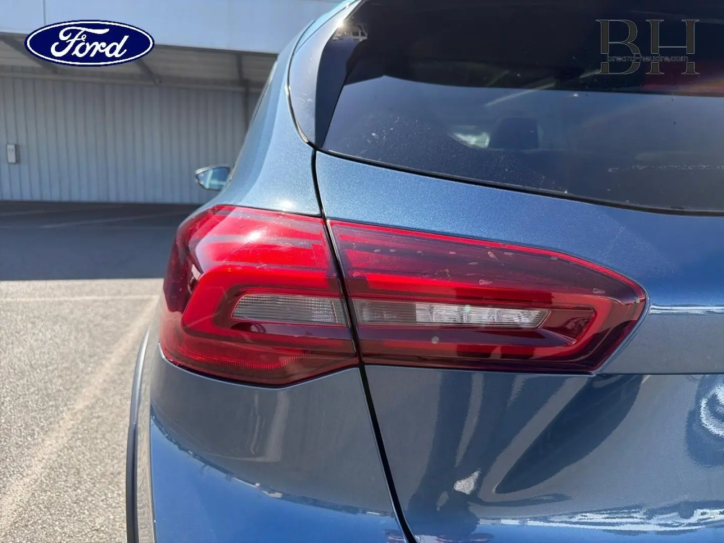 Gros plan sur le feu arrière gauche d'une Ford Focus 2022 bleu azur métallisé, avec carrosserie brillante.