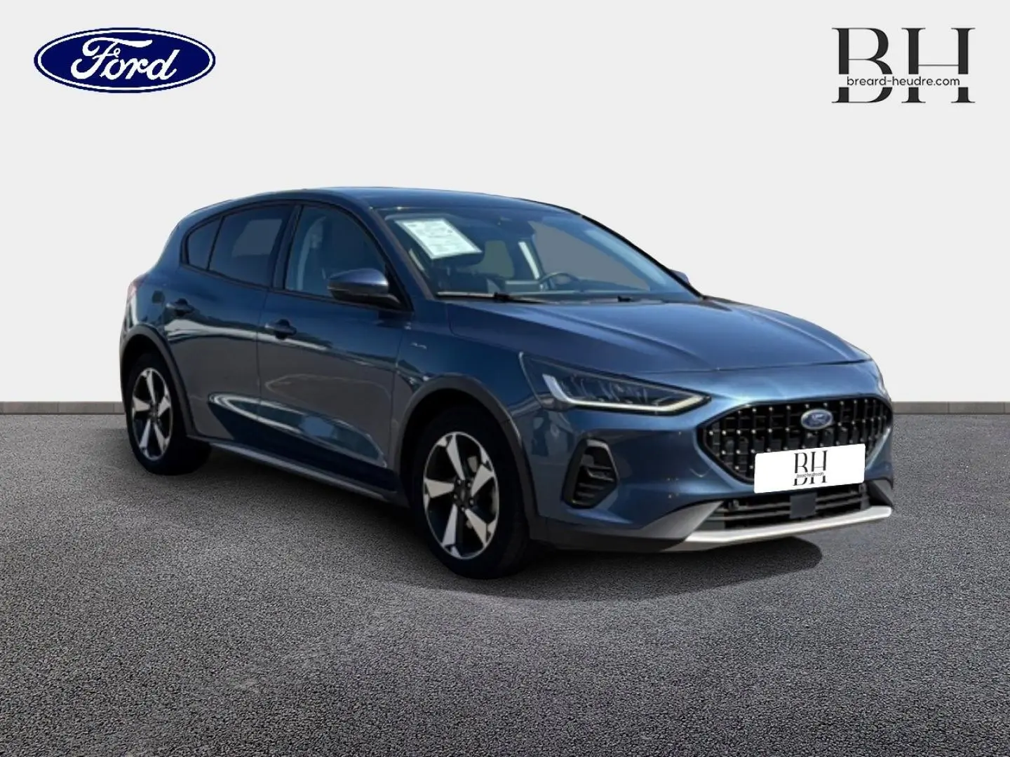 Ford Focus 2022 bleu azur métallisé vue 3/4 avant droit avec calandre noire et jantes alliage bicolores.