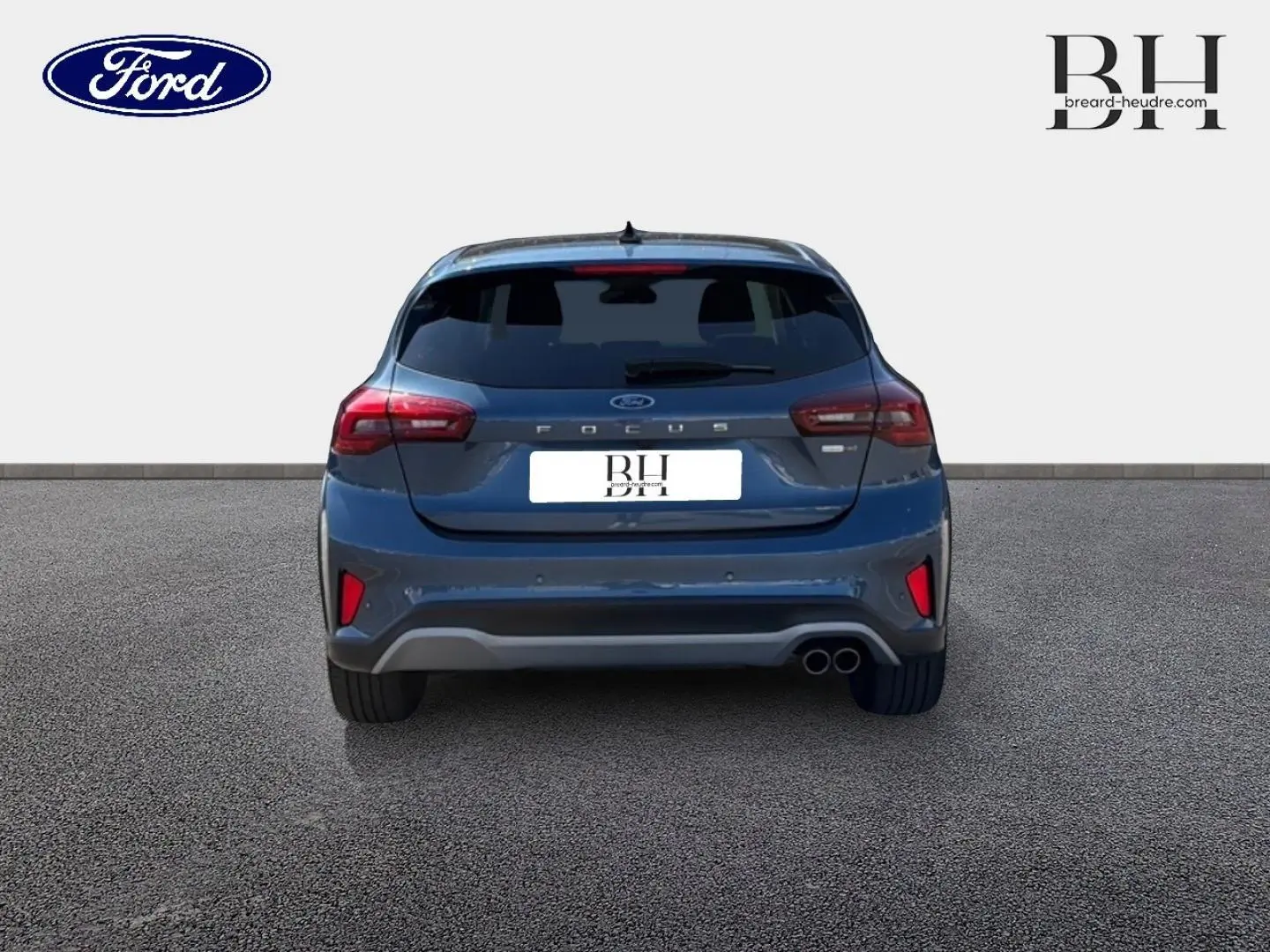 Vue arrière d'une Ford Focus 1.0 Flexifuel bleu azur métallisé avec double sortie d'échappement et vitres arrière surteintées.