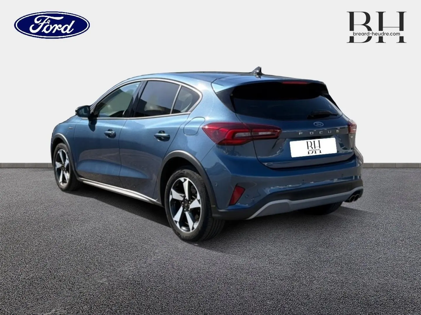 Vue 3/4 arrière droite d'une Ford Focus 2022 bleu azur métallisé avec toit panoramique et vitres arrière surteintées.