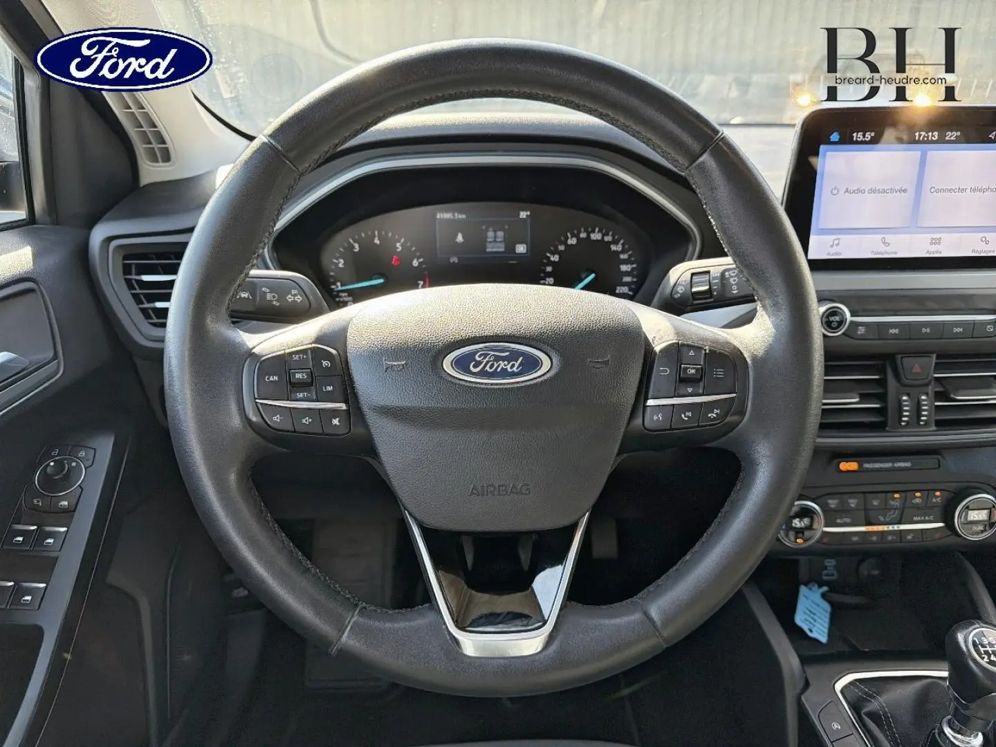 Vue intérieure centrée sur le volant cuir multifonction de la Ford Focus 2022 avec tableau de bord et écran tactile.