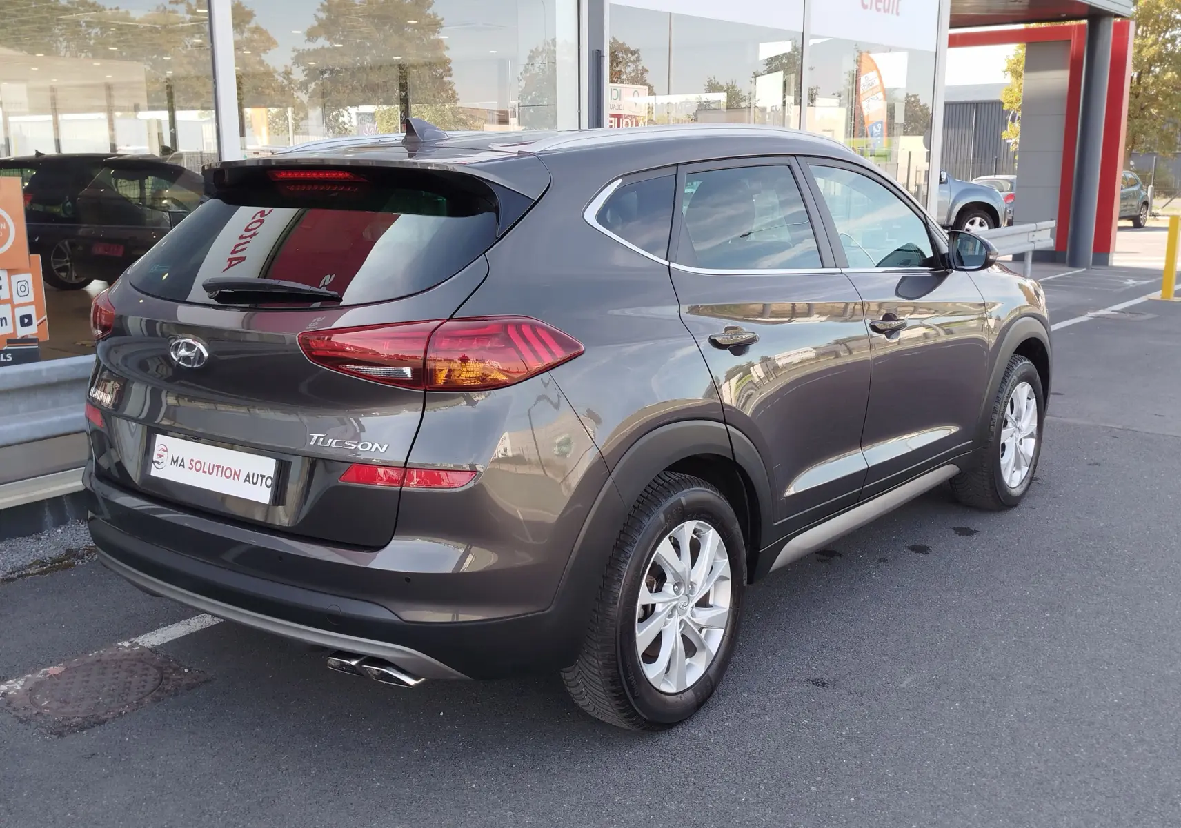 Vue 3/4 arrière droite d'un Hyundai Tucson gris Micron 2019 avec feux arrière LED et jantes alliage.