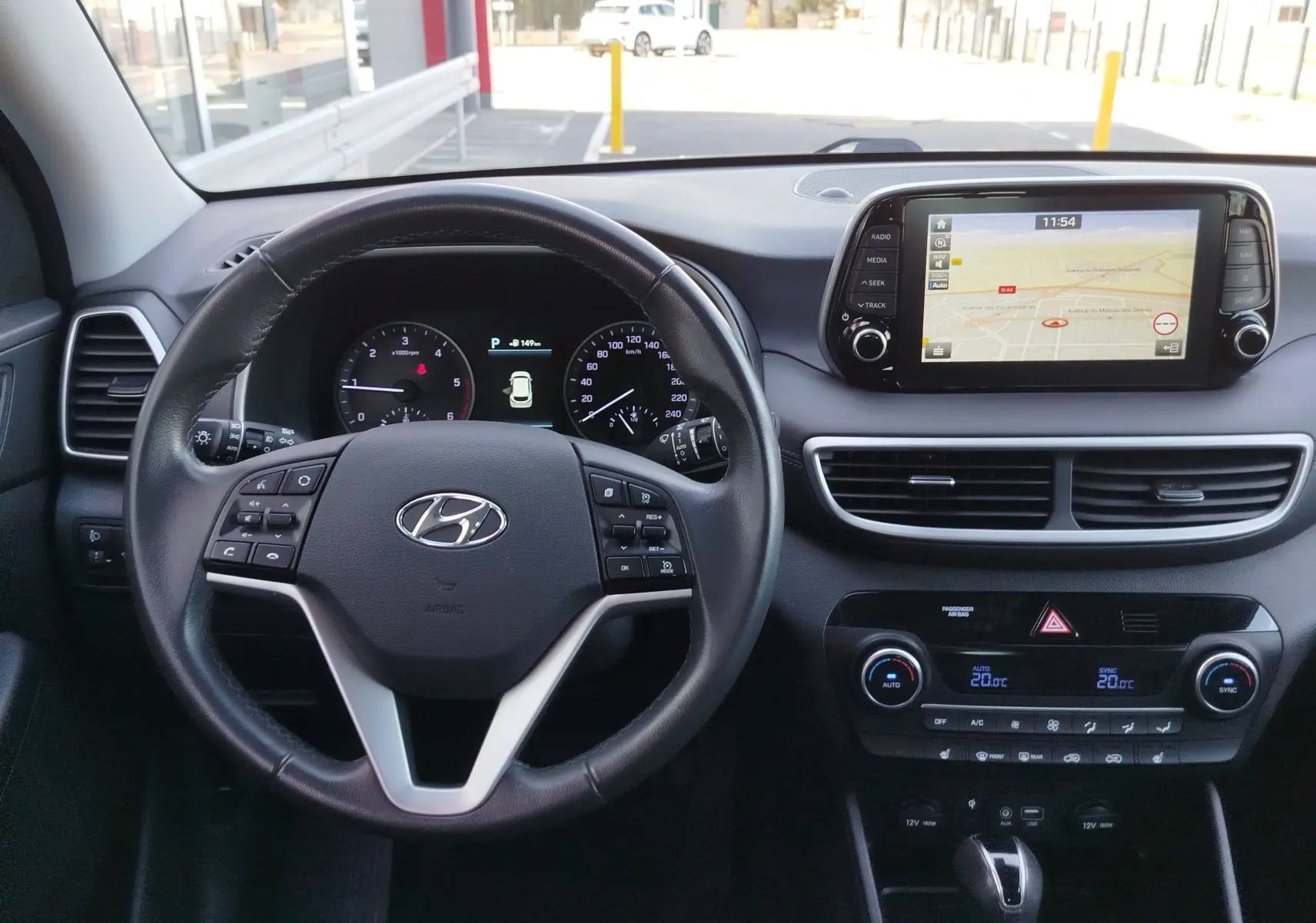 Vue intérieure du tableau de bord du Hyundai Tucson 2019, avec volant cuir, écran tactile et commandes de climatisation.