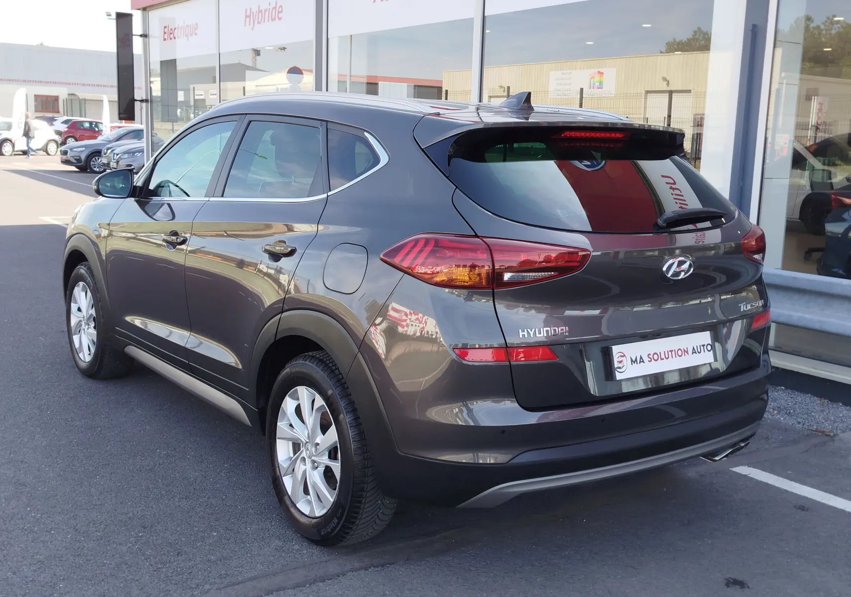 Vue 3/4 arrière droite d'un Hyundai Tucson gris Micron 2019, avec feux arrière allongés et jantes alliage 17 pouces.