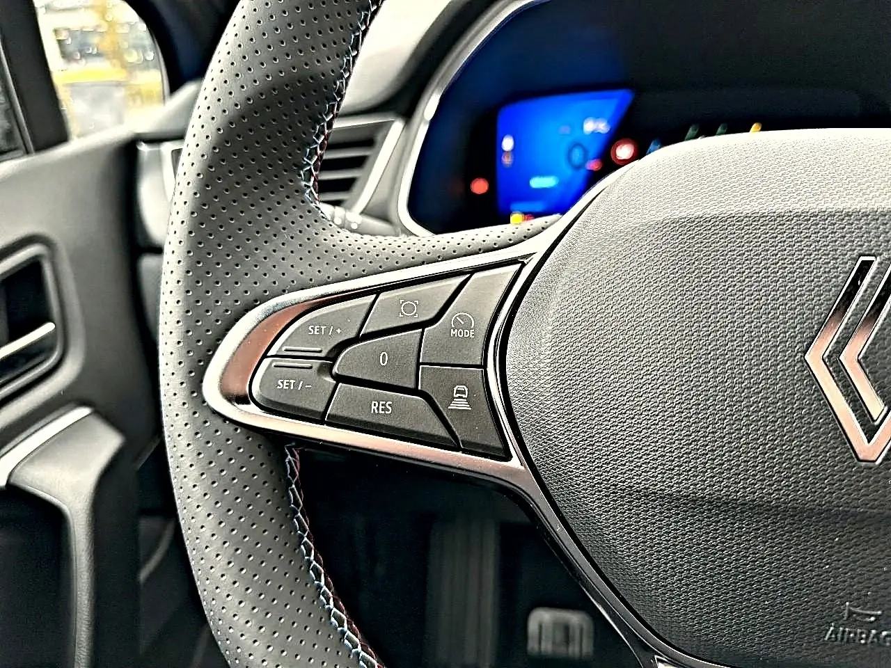 Gros plan sur le côté gauche du volant perforé noir du Renault Symbioz 2026 avec commandes multifonctions visibles.