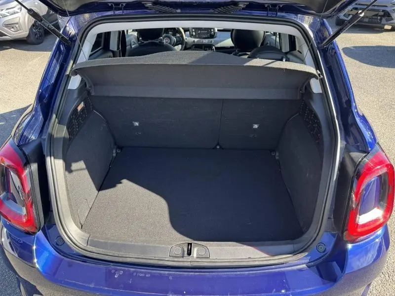 Coffre ouvert vu de l'arrière d'une FIAT 500X bleu, montrant l'espace de chargement et l'intérieur avant.