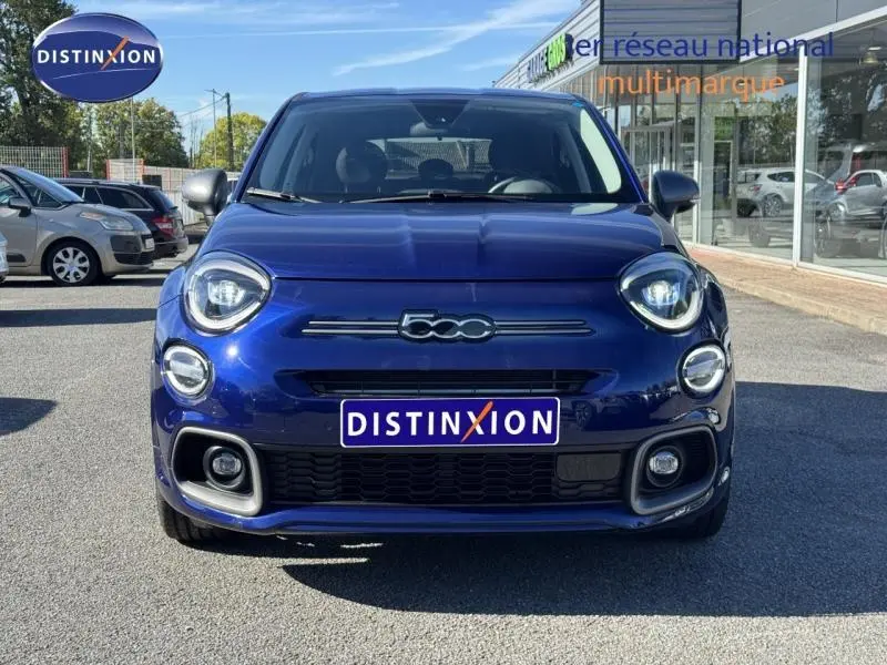 Vue avant d'une FIAT 500X 2024 en bleu, mettant en valeur ses phares ronds LED et sa calandre distinctive.