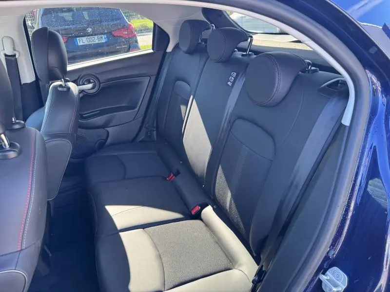 Vue intérieure côté droit montrant la banquette arrière noire avec appuie-têtes et ceinture de sécurité du FIAT 500X 2024.