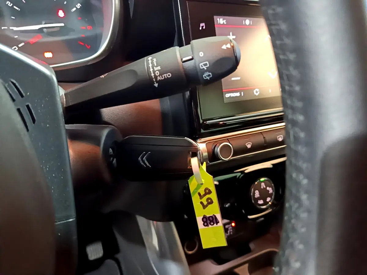 Gros plan sur la commande d’essuie-glace et l’écran tactile du tableau de bord d’un Citroën C3 Aircross noir de 2019.