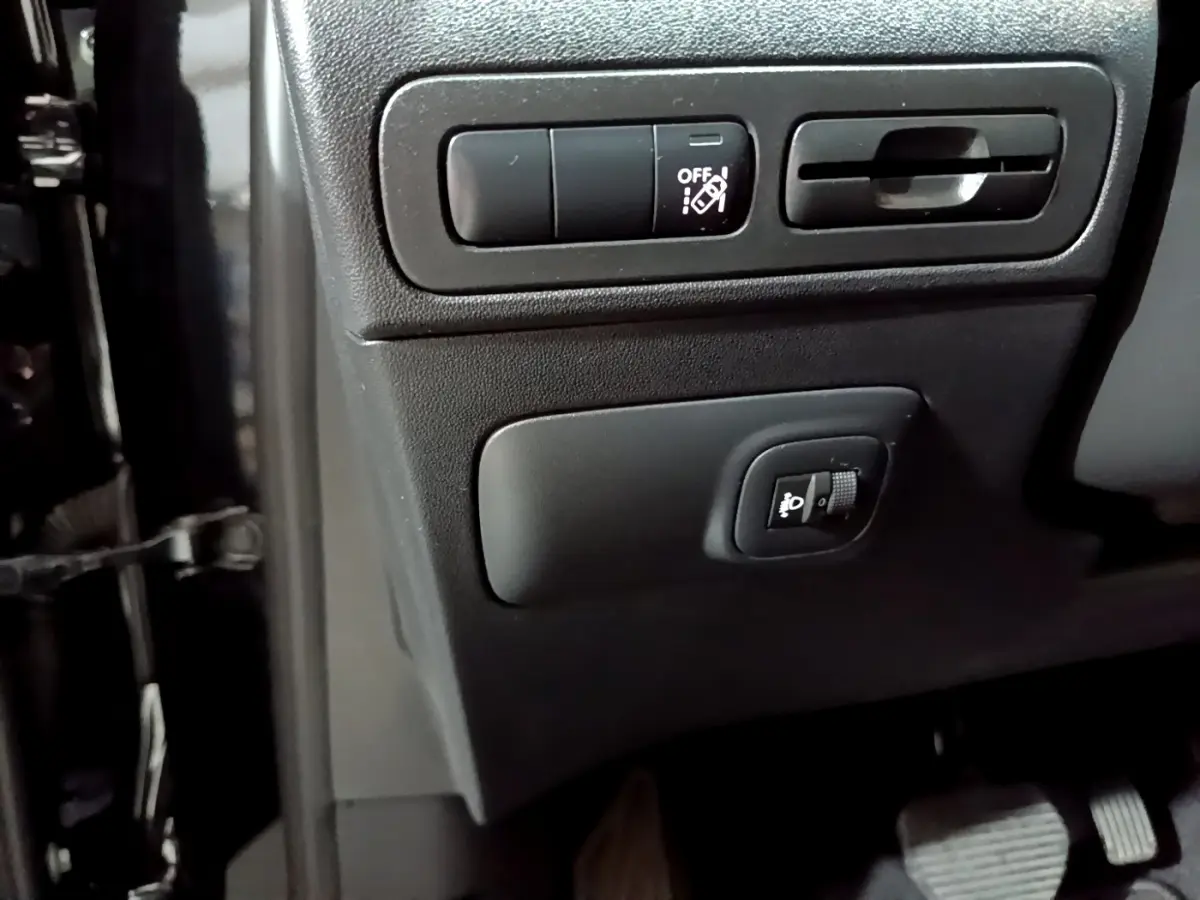 Détail des commandes d'éclairage et sécurité côté gauche du tableau de bord noir du Citroën C3 Aircross 2019.