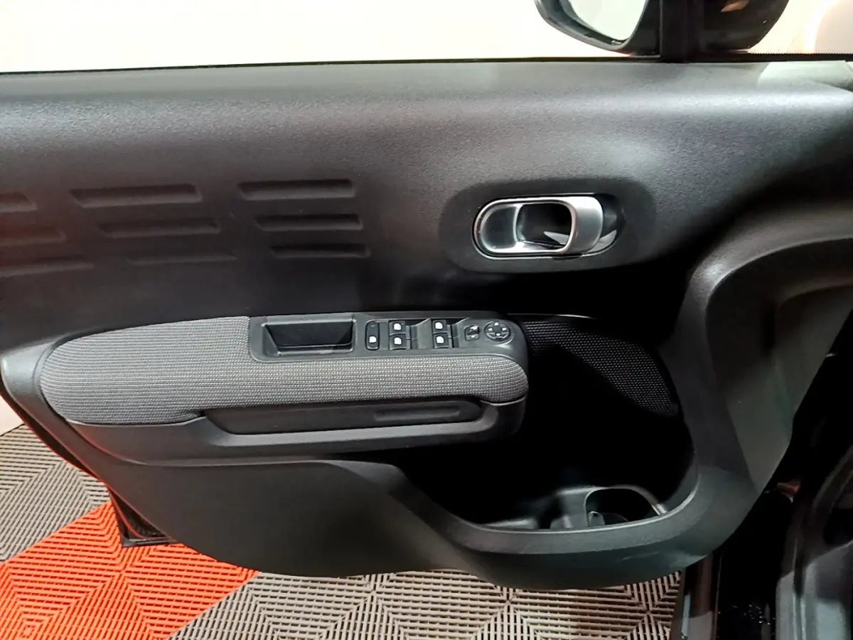 Gros plan sur la porte côté gauche noire du Citroën C3 Aircross 2019 avec commandes de vitres et poignée chrome.