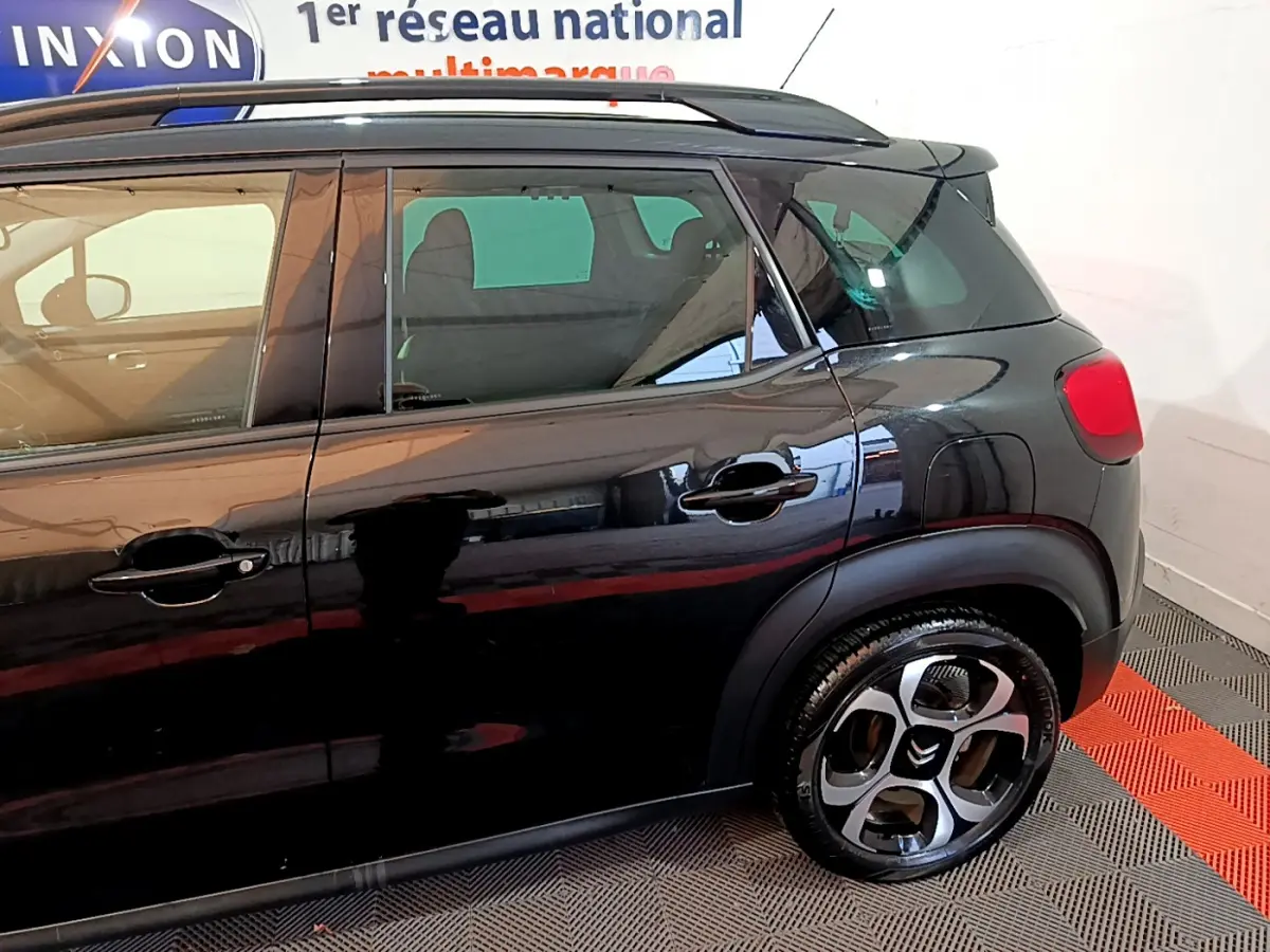 Vue latérale côté droit d'un Citroën C3 Aircross noir, mettant en valeur les portes arrière et la roue arrière.