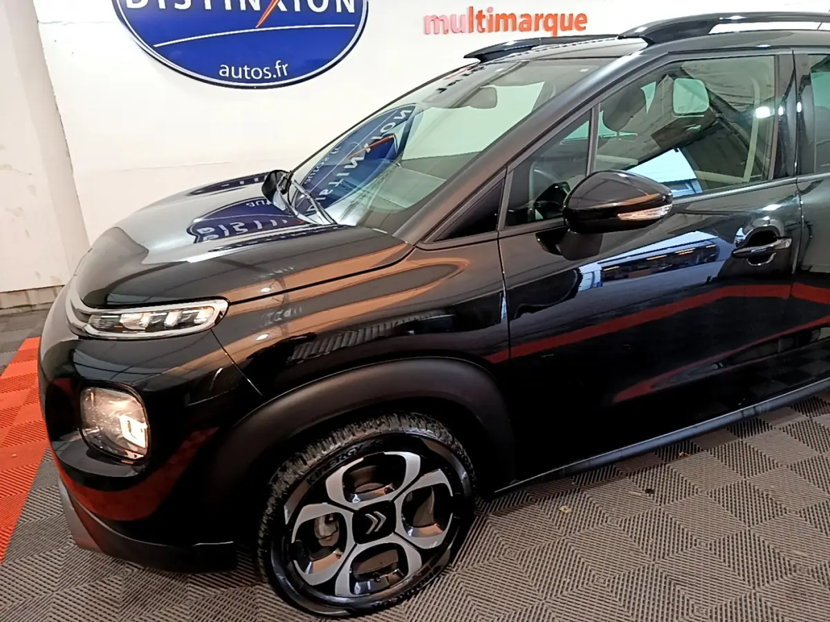Vue 3/4 avant droit d'un Citroën C3 Aircross noir brillant avec jantes distinctives et rétroviseurs ton caisse.