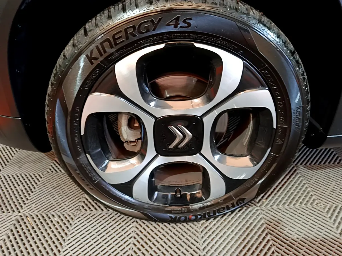 Gros plan sur la jante alliage noire et argentée avec logo Citroën d'un Citroën C3 Aircross noir.